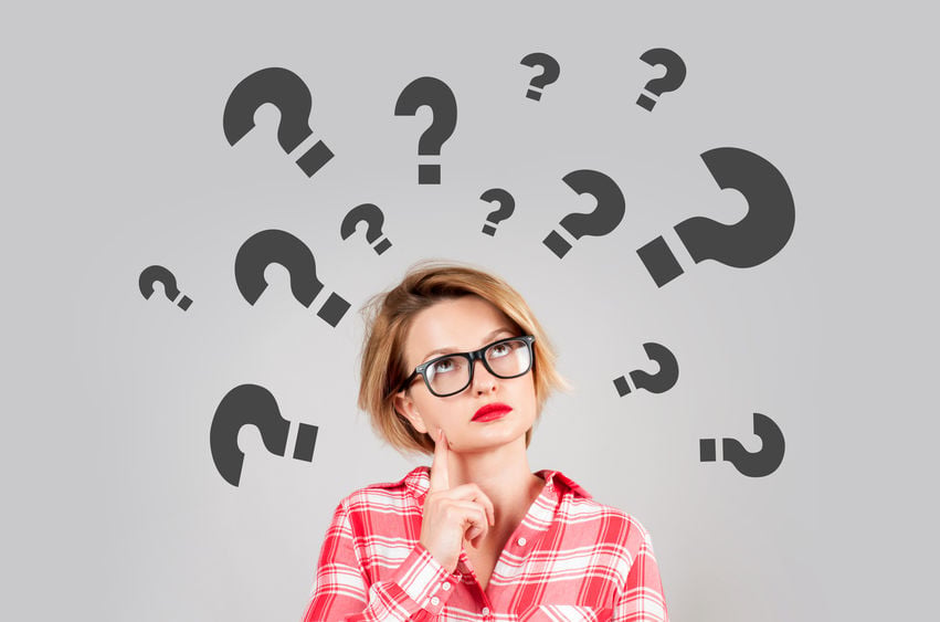 Woman with question marks above her head wondering is it dyslexia or Irlen Syndrome causing her issues.